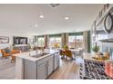 Modern kitchen with stainless steel appliances, a central island, and an adjacent dining area at 7454 Bosco Brook Dr # Lot 48, North Las Vegas, NV 89084