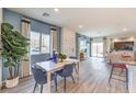 Open-concept living space with dining area featuring a white table, blue chairs, and bright natural light at 7915 Pandora Sky St # 403, North Las Vegas, NV 89084