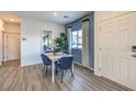 Dining area with white table, blue chairs, and blue accent wall with white trim, near the entry door at 7915 Pandora Sky St # 403, North Las Vegas, NV 89084