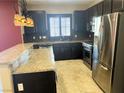 Bright kitchen boasts stainless appliances, dark cabinets, and stone backsplash at 9535 Leaping Lizard St, Las Vegas, NV 89178