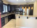Well-appointed kitchen featuring granite countertops, stainless appliances, and dark wood cabinetry at 9535 Leaping Lizard St, Las Vegas, NV 89178