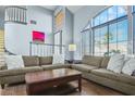 Inviting living room featuring a soaring ceiling, large windows, and comfortable seating at 9709 Terrace Green Ave, Las Vegas, NV 89117
