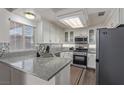 Bright kitchen with granite countertops, stainless steel appliances, and white cabinetry at 10103 Flagstaff Butte Ave, Las Vegas, NV 89148