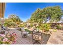 Serene backyard featuring a stone patio, lush landscaping, and comfortable seating areas at 10290 Profeta Ct, Las Vegas, NV 89135