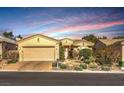 Charming single-story home showcasing a well-manicured front yard and a two-car garage under a colorful sky at 10290 Profeta Ct, Las Vegas, NV 89135