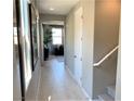 Inviting hallway with light wood floors leading to a cozy living area; adjacent staircase to upper level at 116 Antler Square Ln, Henderson, NV 89011