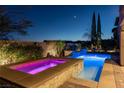 Inviting pool and spa featuring vibrant lighting and lush landscaping for evening relaxation at 12249 Catanzaro Ave, Las Vegas, NV 89138