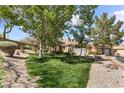 Beautiful single-story home with lush landscaping and mature trees creating a serene and inviting outdoor space at 2037 Summer Blossom Ct # 101, Las Vegas, NV 89134