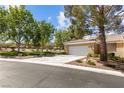Well-maintained single-story home with a spacious driveway and attached garage, framed by mature trees at 2037 Summer Blossom Ct # 101, Las Vegas, NV 89134
