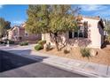 A well-maintained front yard with desert landscaping and mature shade trees at 235 Desert Arroyo Ct, Henderson, NV 89012