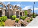 Inviting front yard with desert landscaping, a brick walkway, and covered porch at 2422 Fasano St, Henderson, NV 89044