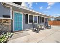 Inviting front porch with a vibrant blue door, seating, and landscaped entryway at 2447 Tournament St, Las Vegas, NV 89142