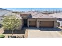 Aerial front exterior view of a desert home with a tile roof and a paved driveway at 2719 Canvas Sky St, Henderson, NV 89044