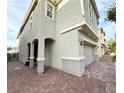 A side view of the charming home showcasing the two-car garage and brick paved driveway at 2922 Tranquil Brook Ave, Henderson, NV 89044