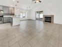 Spacious living room with vaulted ceilings, fireplace, tile floors, and sliding doors to the backyard at 3308 Paragon Dr, Las Vegas, NV 89117
