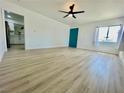 Spacious living room with vinyl floors, a window, and a bright teal door at 4324 El Conlon Ave, Las Vegas, NV 89102