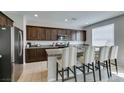 Modern kitchen features dark cabinets, stainless steel appliances and a granite countertop island with seating at 4642 Chirping St, North Las Vegas, NV 89031