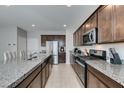 Spacious kitchen featuring granite countertops, stainless steel appliances and dark wood cabinetry at 4642 Chirping St, North Las Vegas, NV 89031