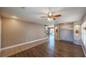 Inviting living room with wood floors, a ceiling fan, built-in shelving, and a staircase at 5031 Naff Ridge Dr, Las Vegas, NV 89131