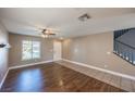 Well-lit living room boasting wood floors, a ceiling fan, front door and a staircase at 5031 Naff Ridge Dr, Las Vegas, NV 89131