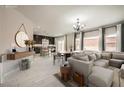 This home features a living room connected to a kitchen, with white tile floors throughout at 5340 Kennedy Hill Ave, Las Vegas, NV 89139