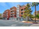 Condominium building exterior with garage parking, trees, and balconies, offering a charming urban living experience at 55 E Agate Ave # 309, Las Vegas, NV 89123
