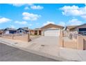Street view of a cozy home featuring a driveway, garage, and white wrought iron fence at 5530 Berchmans Ave, Las Vegas, NV 89122