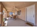 Covered front porch features an outdoor table and chairs, a ceiling fan and a 'welcome' mat at the front door at 5530 Berchmans Ave, Las Vegas, NV 89122