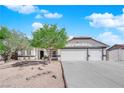 Charming single-story home featuring a three car garage, desert landscaping and a tile roof at 6150 W Brooks Ave, Las Vegas, NV 89108
