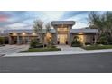 Modern home exterior featuring a three-car garage, lush landscaping, and sleek architectural lines at 667 Palisade Rim Dr, Henderson, NV 89012