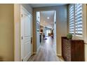 Inviting hallway with wood-look flooring, leading to the main living area, with shuttered window at 8036 Literature Ct, Las Vegas, NV 89113