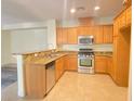 Bright kitchen with stainless steel appliances and a breakfast bar with granite countertops at 8374 Pioneer Way, Las Vegas, NV 89113