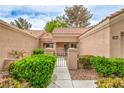 Home's entryway features a secure gate, desert landscaping, and a covered entrance leading to the front door at 8513 Glenmount Dr, Las Vegas, NV 89134