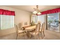 Bright dining room with a chandelier, and sliding glass doors to the patio at 8861 Hampton Green Ave, Las Vegas, NV 89129