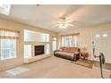 Cozy living room with fireplace, neutral carpet, and abundant natural light at 8861 Hampton Green Ave, Las Vegas, NV 89129