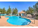 Community pool area featuring a beautiful pool, lounge chairs, and a cabana at 8861 Hampton Green Ave, Las Vegas, NV 89129