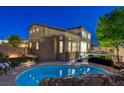 Backyard featuring a swimming pool with a rock waterfall feature, an artificial lawn, and covered patio area at 9413 Artesian Oak Ct, Las Vegas, NV 89149