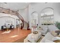 Spacious living room featuring a grand staircase, tile floors, archways, high ceilings, and lots of natural light at 9413 Artesian Oak Ct, Las Vegas, NV 89149