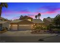 Dusk view of a home with a three-car garage and desert landscaping at 1508 Sun Copper Dr, Las Vegas, NV 89117