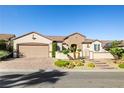 Charming single-story home featuring desert landscaping, a brick-paved driveway, and gated courtyard entry at 2373 Black River Falls Dr, Henderson, NV 89044