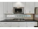 Up close shot of a kitchen with white cabinets and stainless steel appliances at 2445 Antler Point Dr, Henderson, NV 89074