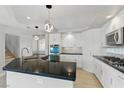 Modern kitchen features white cabinets, black countertops, and stainless steel appliances at 2445 Antler Point Dr, Henderson, NV 89074