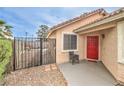 Cozy home entryway showcasing a red front door, gated courtyard, and well-maintained desert landscape at 2744 Ironside Dr, Las Vegas, NV 89108