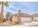 Inviting single-story home with a two-car garage, desert landscaping, and a well-manicured lawn at 2744 Ironside Dr, Las Vegas, NV 89108