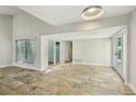 Open living area with tiled floors and multiple doors to outdoor atrium spaces, providing ample light at 3177 Bel Air Dr, Las Vegas, NV 89109