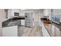 Updated kitchen with stainless steel appliances, granite countertops, and white cabinetry at 42 Megan Dr, Henderson, NV 89074