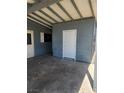 A sheltered carport and a closed room with a white door and grey paneling at 4536 Payson Ave, Las Vegas, NV 89115
