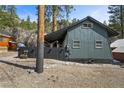 Charming grey home with a dark metal roof and a fenced yard, with wooded views at 4578 Yellow Pine Ave, Mount Charleston, NV 89124