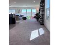 Bright living room with plush carpet, natural light, and modern decor at 4993 Birchland Manor Ave, Las Vegas, NV 89139