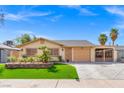 Inviting single-story home with a well-manicured lawn, mature palm trees, and a convenient attached carport at 5001 Morris St, Las Vegas, NV 89122